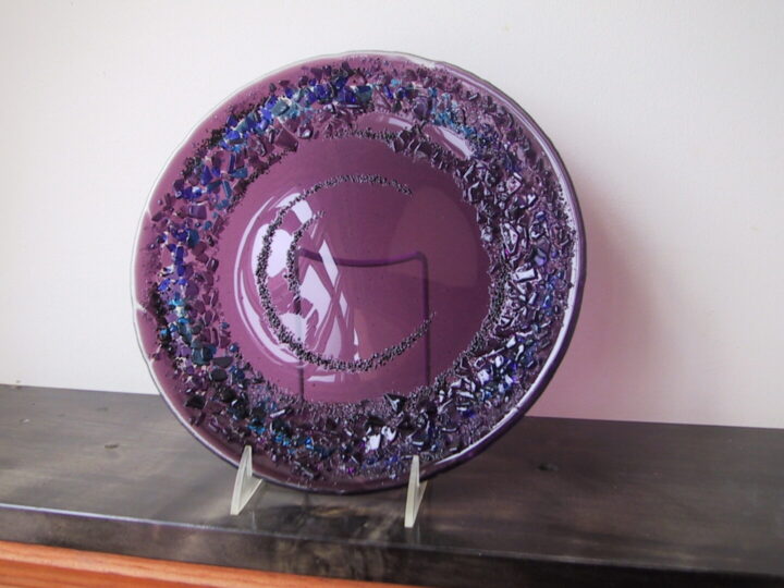 nearly opaque amethyst colored glass plate encrusted with purple and blue glass chips around the circumference of the plate